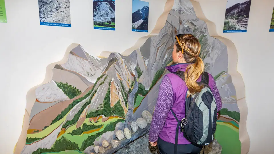 Besucherin vor einem Gebirgsrelief in der Geologie-Ausstellung