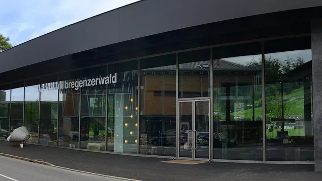 Modernes Glasgebäude mit Eingang und der Beschriftung 'bregenzerwald' an der Front.