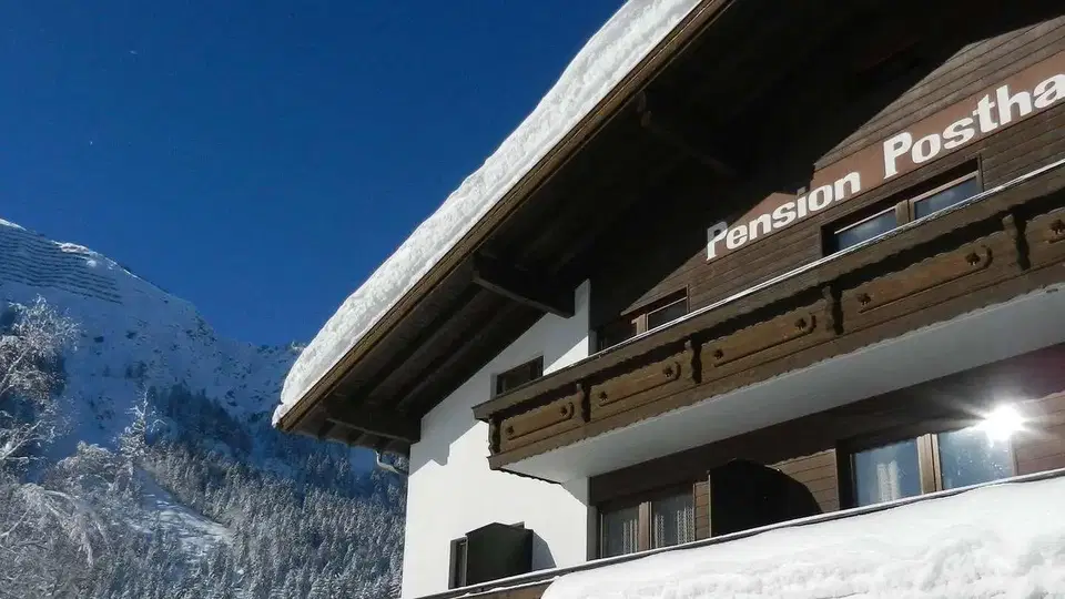 Pension Posthansl im Winter vor verschneiten Bergen