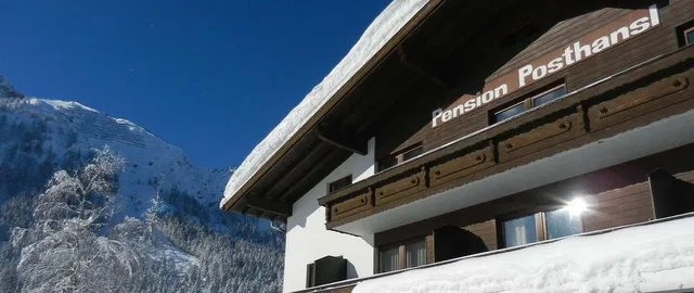 Pension Posthansl im Winter vor verschneiten Bergen
