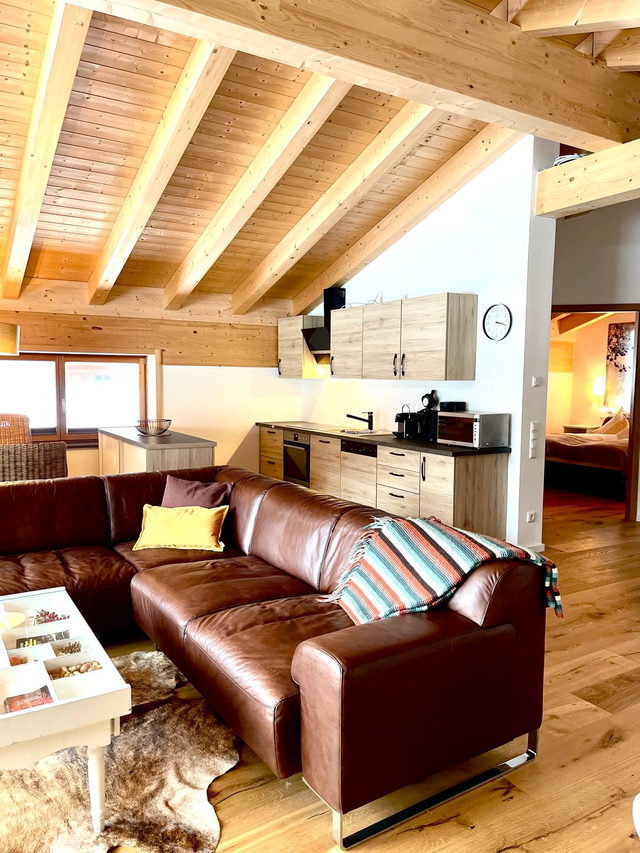 Wohnbereich mit Sofa und offener Küche in der Ferienwohnung Solara