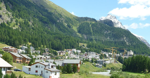 Pontresina mit Häusern am Fluss und Berglandschaft