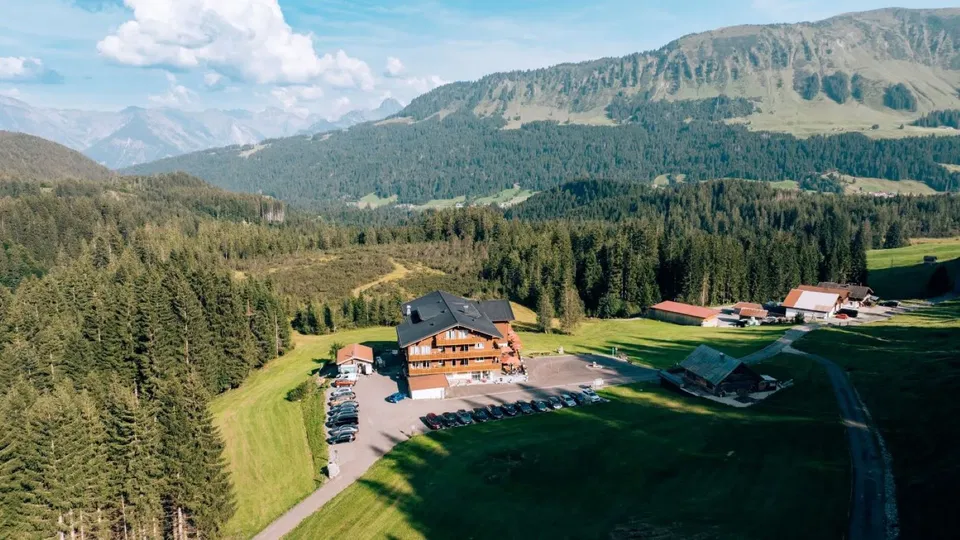 Alpengasthof Hörnlepass aus der Luft mit Bergkulisse und umliegenden Wiesen