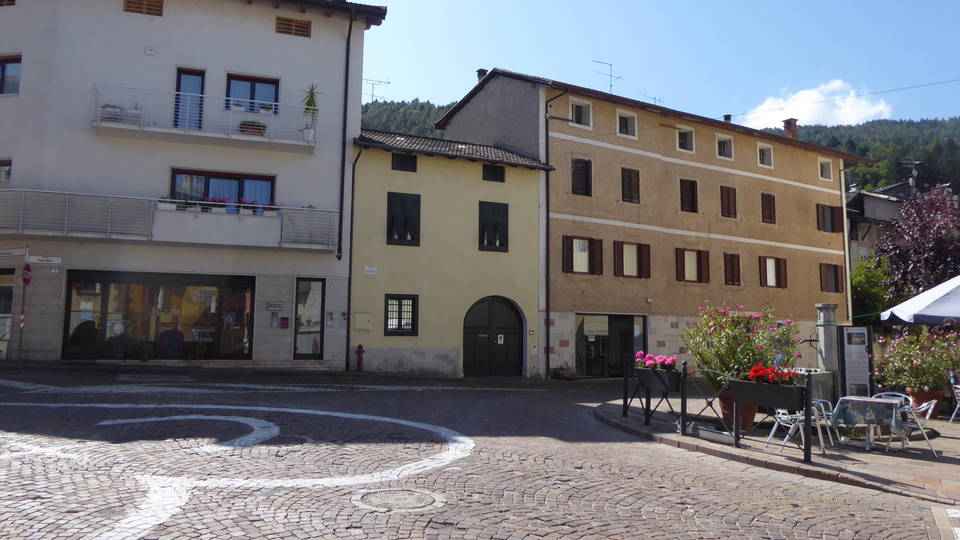 Historischer Platz mit gepflasterten Flächen und Häuserfassaden im Zentrum von Caldonazzo