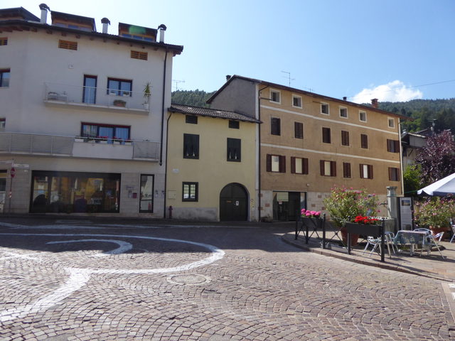 Historischer Platz mit gepflasterten Flächen und Häuserfassaden im Zentrum von Caldonazzo