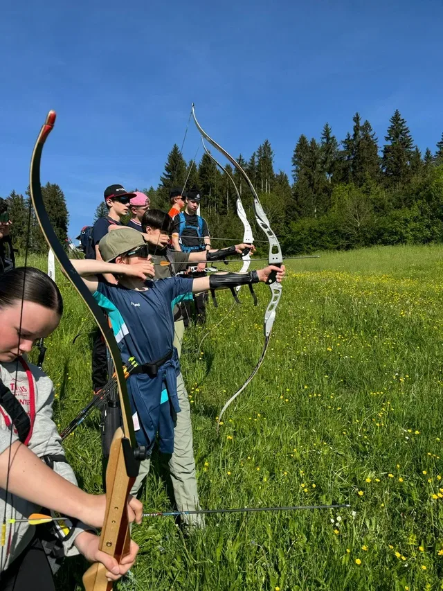 Gruppe mit Bögen auf einer Blumenwiese