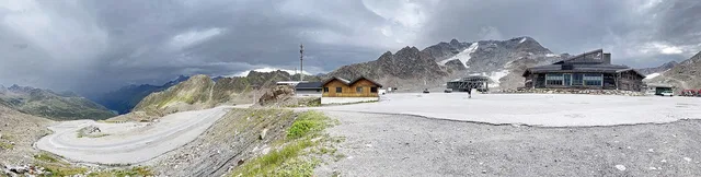 Berglandschaft mit Holzhäusern auf einer offenen Hochfläche
