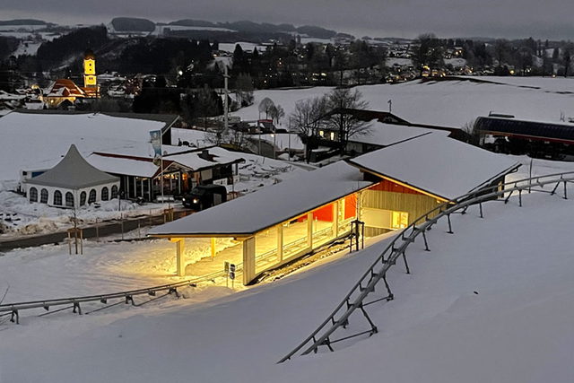 Beleuchtetes Stationsgebäude des AlpspitzCOASTER im verschneiten Nesselwang.
