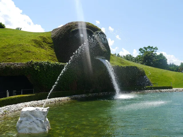 Begrünte Skulptur mit Fontänen an einem Wasserbecken