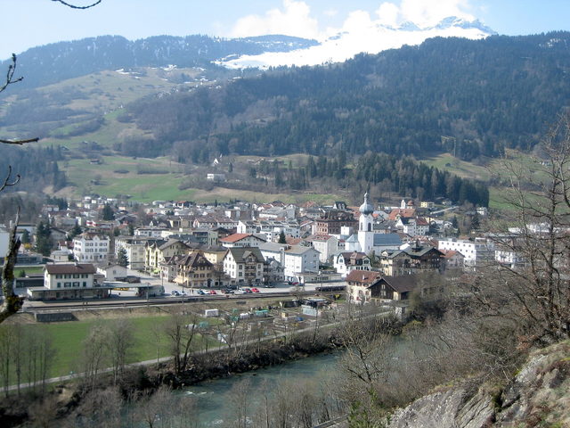 Ilanz mit Altstadt und Fluss vor bewaldeten Berghängen