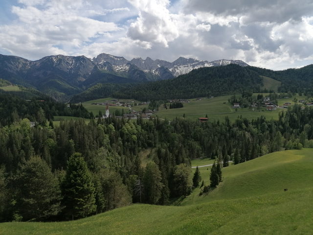 Grüne Wiesen und Dorf Steinberg am Rofan vor der Bergkulisse