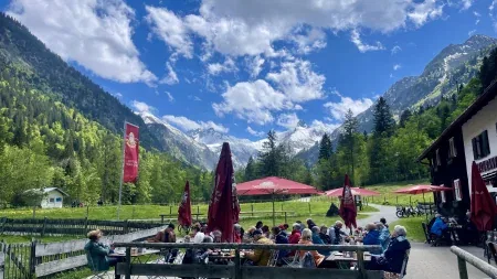Sonnenterrasse des Café-Restaurants Christlessee mit Gästen und Bergblick