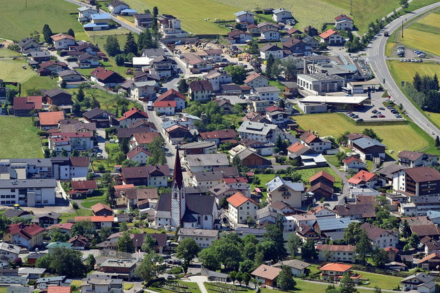 Blick von Farst auf den Ortskern von Umhausen mit Kirche und Wiesen