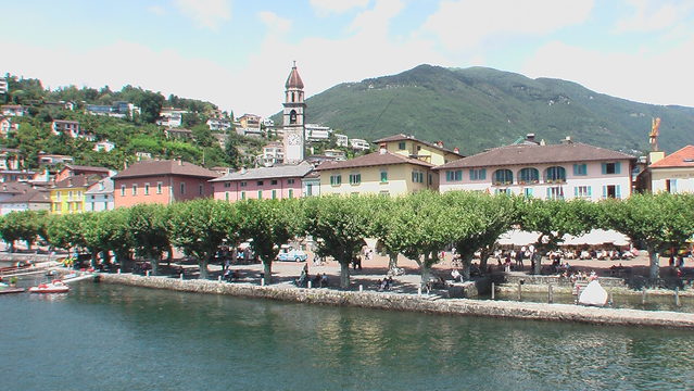 Bunte Häuser der Seepromenade Ascona mit dem Glockenturm von San Pietro e Paolo