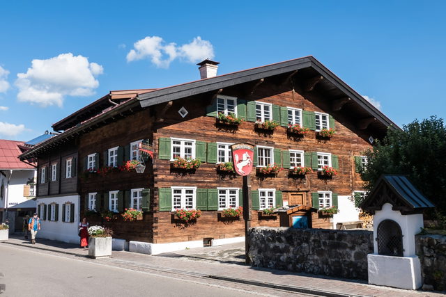 Historisches Holzhaus mit grünen Fensterläden und Museumsschild