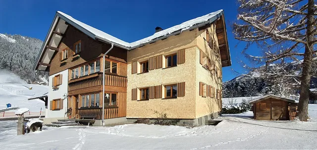 Haus Zunzer mit Schnee und blauem Himmel