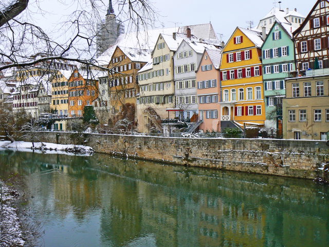 Bunte historische Häuser der Tübinger Neckarfront spiegeln sich im Neckar.