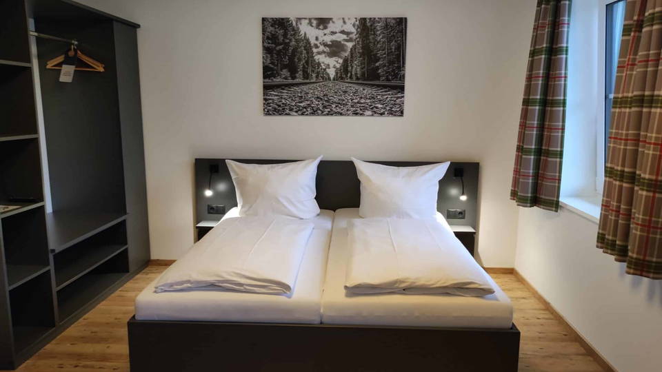 Standard-Doppelzimmer mit Doppelbett und offenem Kleiderschrank