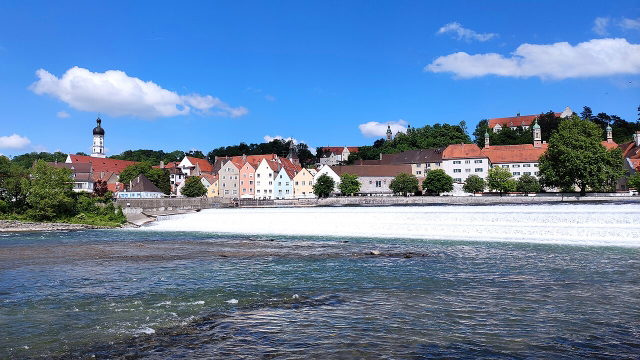 Landsberger Altstadt mit Lechwehr, bunten Häusern und Kirchtürmen am Fluss
