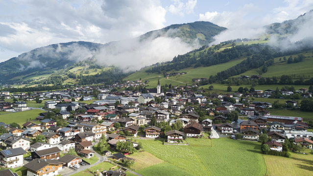 Uttendorf im Salzachtal mit Kirche, Häusern und grünen Berghängen