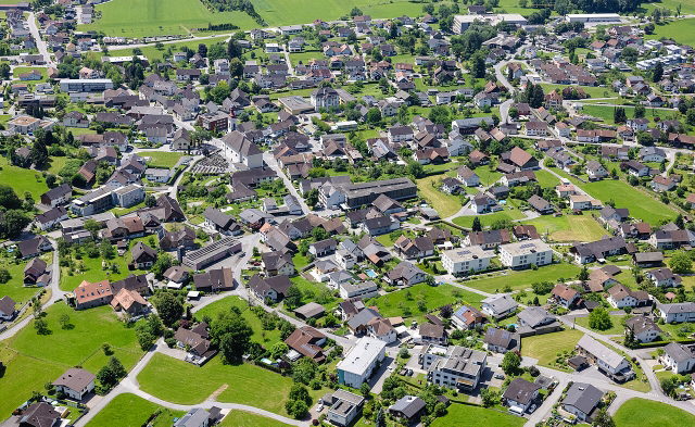 Schrägluftbild von Satteins mit der Pfarrkirche St. Georg und dem Dorfumfeld