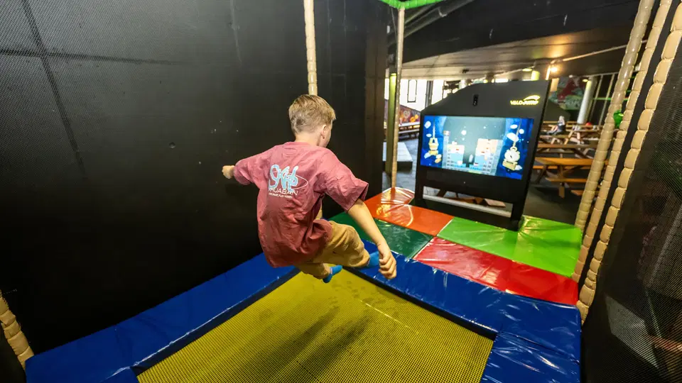 Kind beim interaktiven Trampolinspringen im WONNILAND