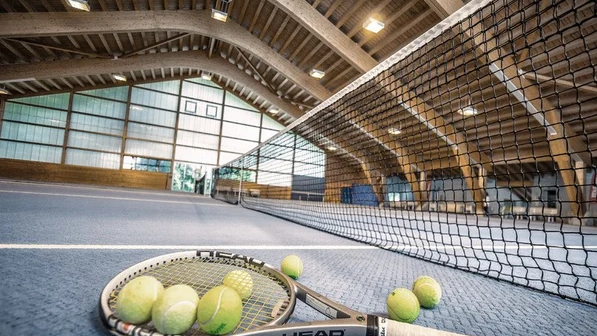 Tennisschläger und Bälle am Netz der Tennishalle im Hotel Valsana in Arosa