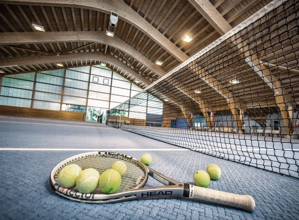 Tennisschläger und Bälle am Netz der Tennishalle im Hotel Valsana in Arosa