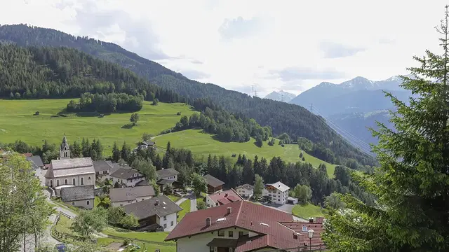 Fendels mit Pfarrkirche und Häusern vor grünen Berghängen (Archivaufnahme).