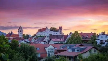Abendstimmung über Füssen mit roten Dächern und Burg im Hintergrund