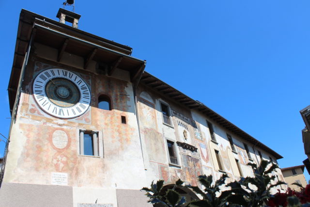 Fanzago-Uhr und bemalte Rathausfassade an der Piazza dell’Orologio in Clusone