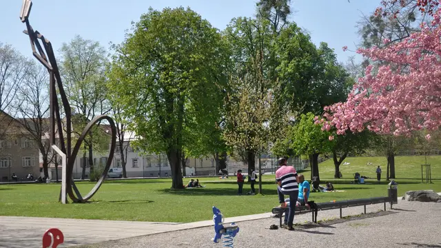 Wiese mit Stahlskulptur, Bäumen und Spielgeräten im Stadtgarten Weingarten. Ortsmotiv zur Ausflugsplanung.