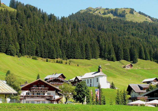 Baad im Kleinwalsertal mit der Kirche St. Martin vor Wald und Bergwiesen
