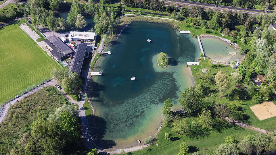 Luftaufnahme des Naturbads Untere Au in Frastanz mit Badesee und Liegewiesen