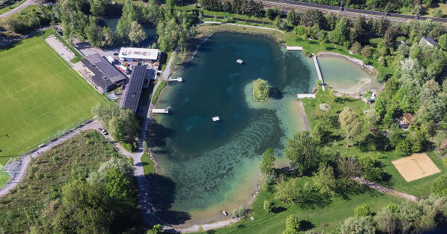 Luftaufnahme des Naturbads Untere Au in Frastanz mit Badesee und Liegewiesen