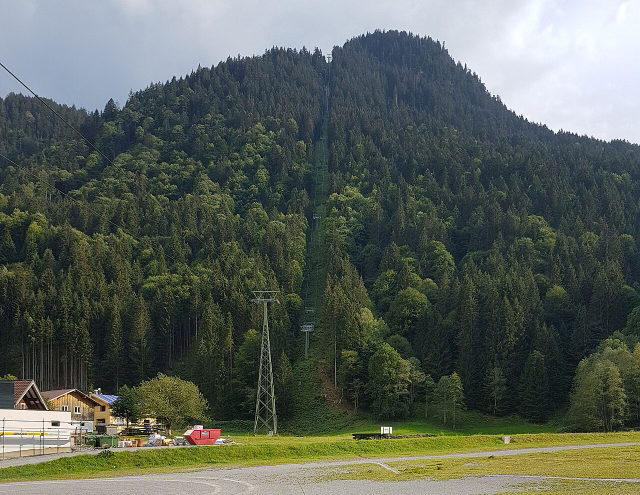 Strecke der Valiserabahn mit Gondeln über einem bewaldeten Hang