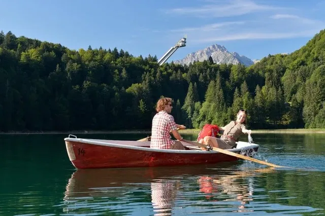 Boot auf dem Freibergsee vor Wald- und Berglandschaft