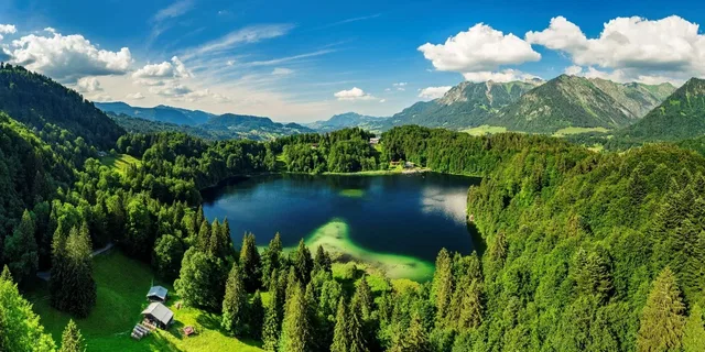 Freibergsee als natürlicher Badebereich vor Wald und Bergen