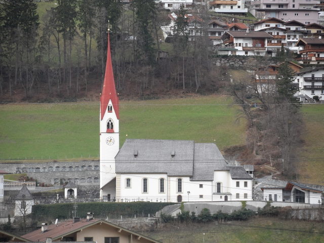 Pfarrkirche von Hippach vor Wiesen und Berghängen