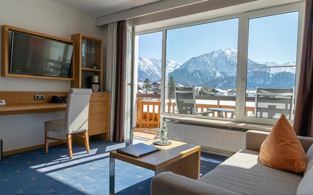 Hotelzimmer mit Balkon, Alpenblick, Sofa und Schreibtisch