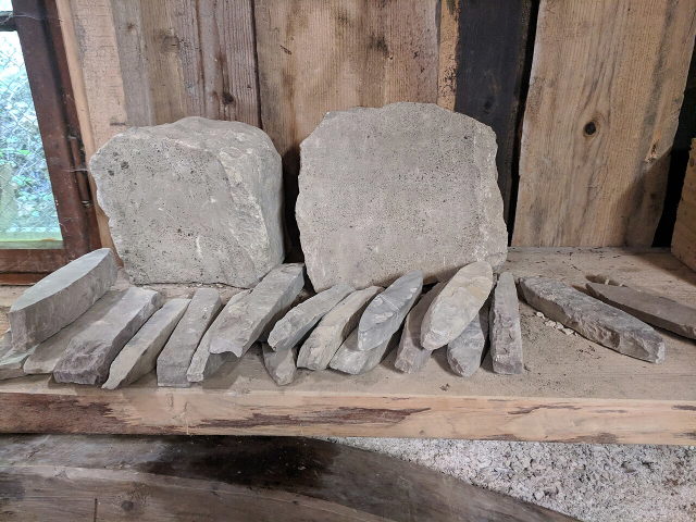 Historische Wetzsteine aus Unterammergau auf einem Holzregal