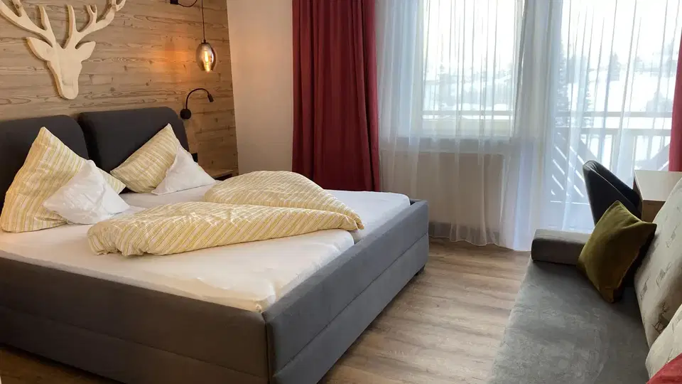 Doppelzimmer mit Doppelbett, Sitzbereich und Balkon