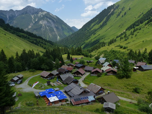 Holzhütten und Berglandschaft im Almdorf Fallerschein