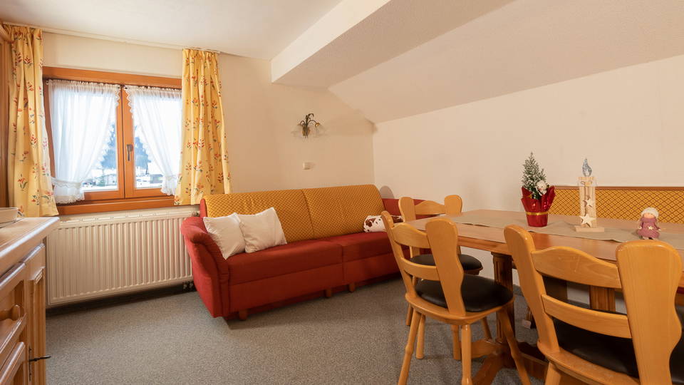 Wohnbereich der Ferienwohnung Bärenkopf mit rotem Sofa