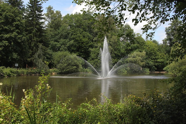 Teich mit Springbrunnen und Bäumen im Kurpark Bad Wörishofen