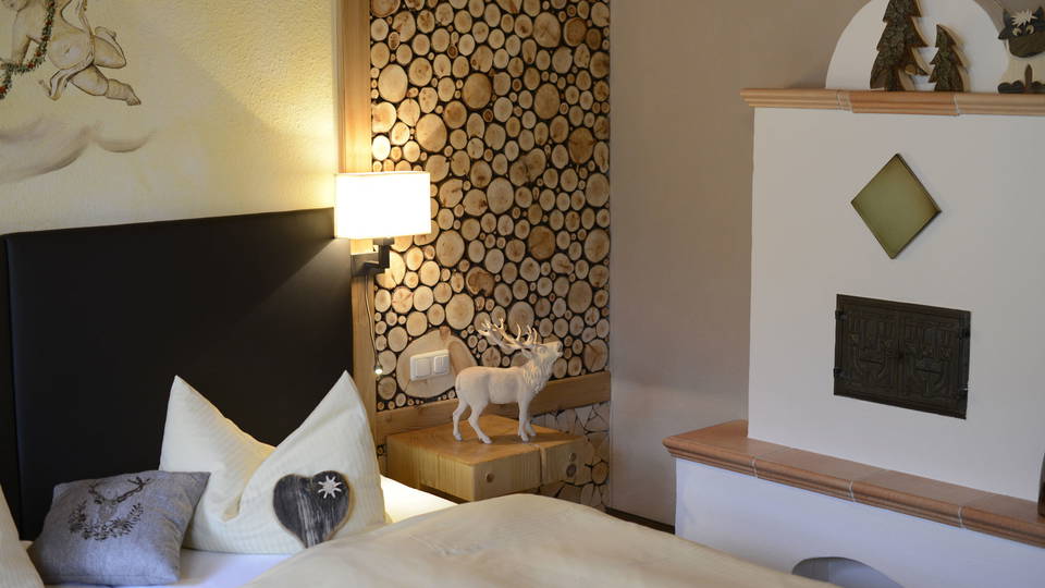 Bett und Kamin im Appartement Schrofenstube