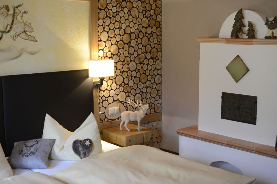 Bett und Kamin im Appartement Schrofenstube
