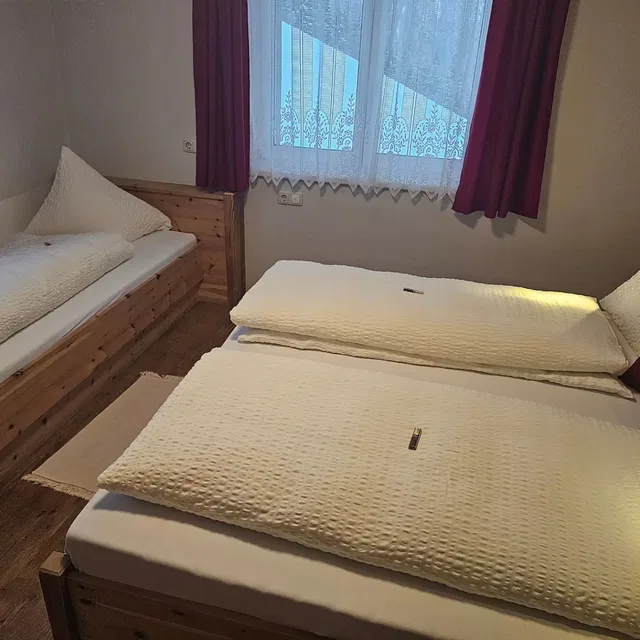 Schlafzimmer der Ferienwohnung Zirbentraum mit zwei Betten im Schwendehof