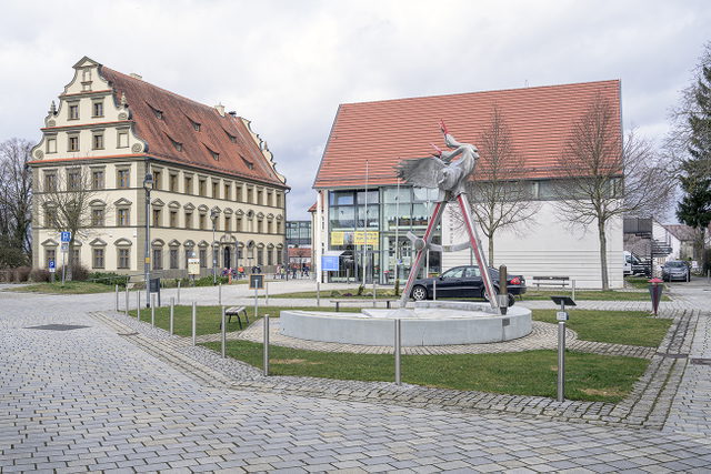 Bayerisches Schulmuseum in Ichenhausen mit historischem Schlossbau links, modernem Eingang rechts, Skulptur und gepflastertem Vorplatz