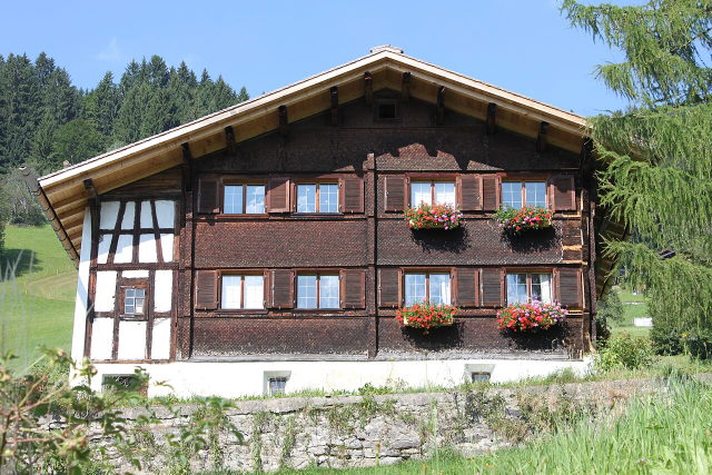 Historisches Frühmesshaus in Bartholomäberg mit Fachwerk und blumengeschmückten Fenstern